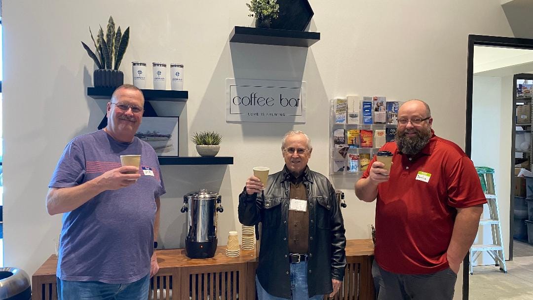 Three men laughing together at the church coffee bar